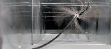 Inside of a duct being cleaned with a rotating brush.